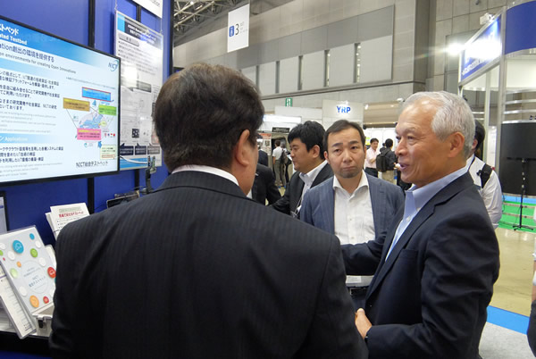 NICT総合テストベッドの展示を視察する徳田理事長